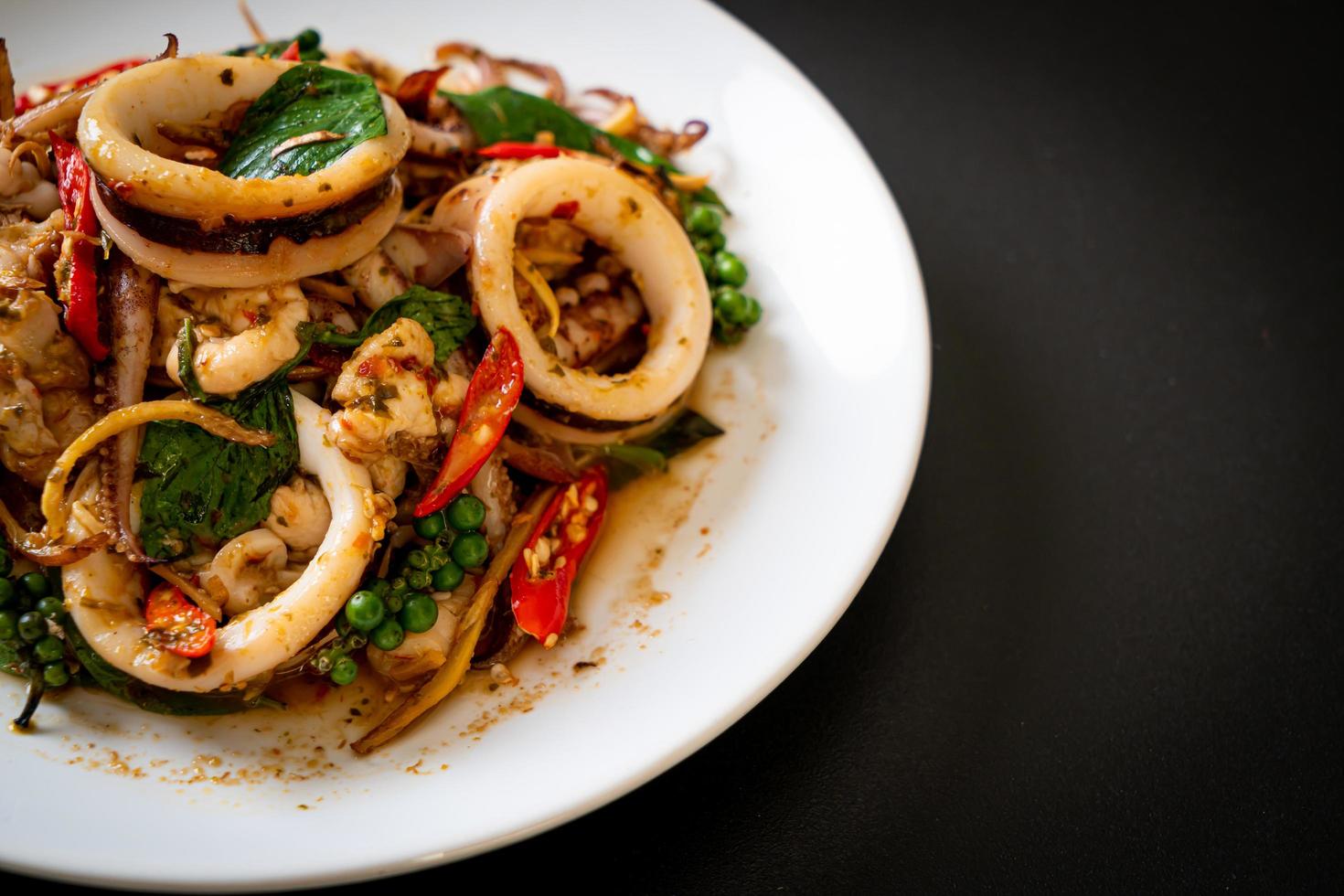 basilic sacré sauté avec poulpe ou calmar et herbes - style cuisine asiatique photo