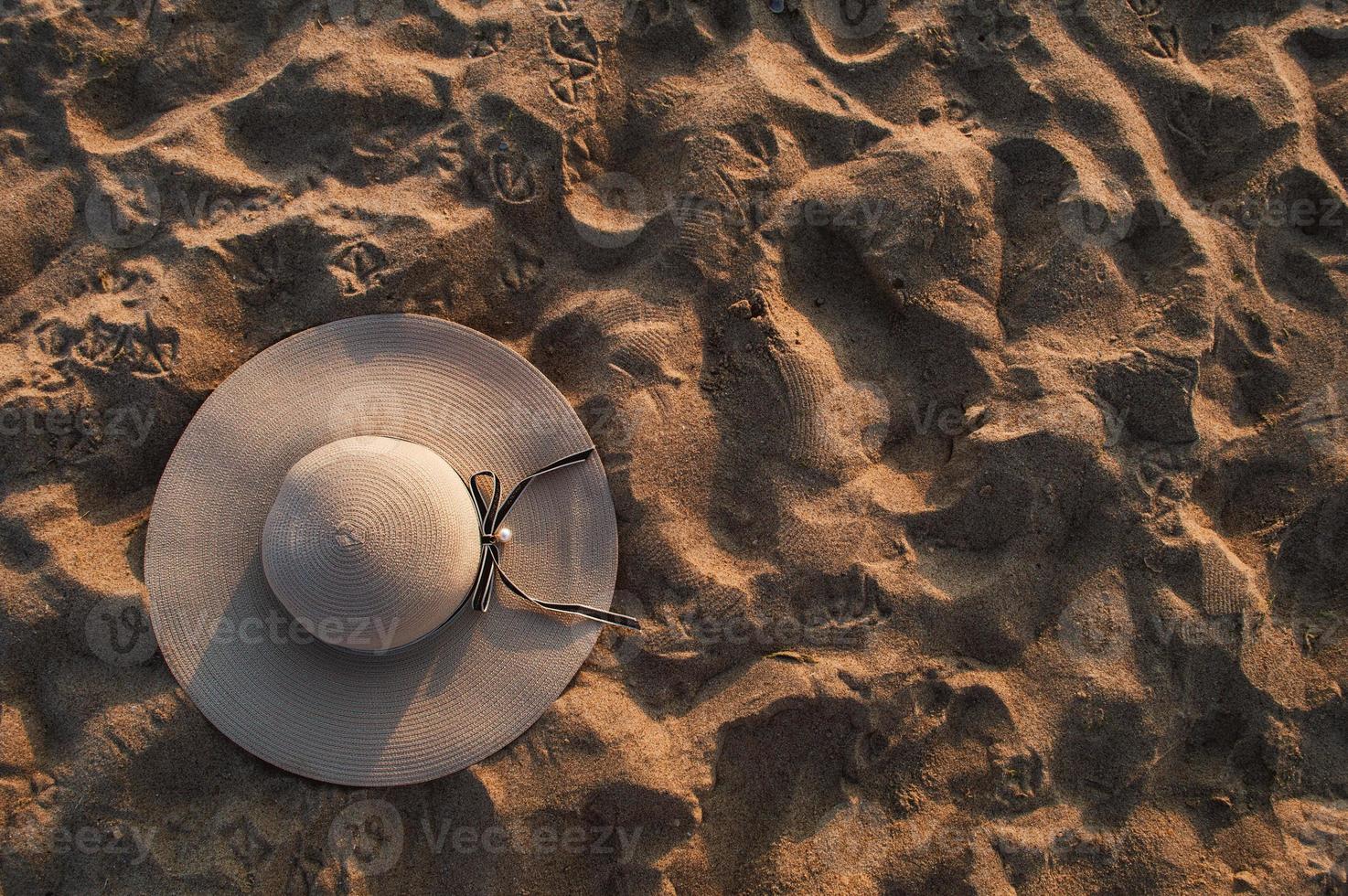 fond de plage de sable avec chapeau d'été à la lumière du soleil photo
