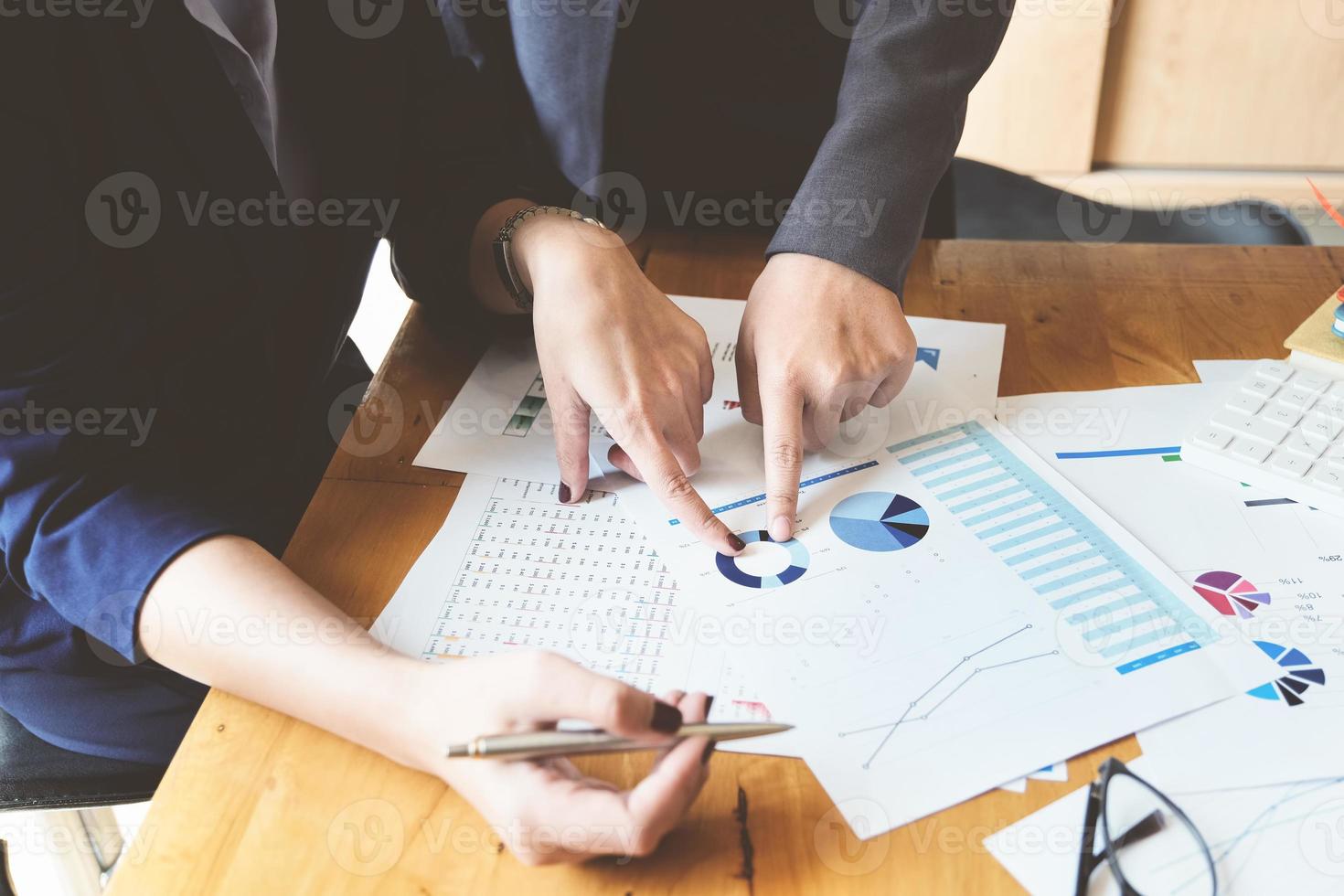 un auditeur pointant des documents pour examiner les budgets et les fraudes financières. photo