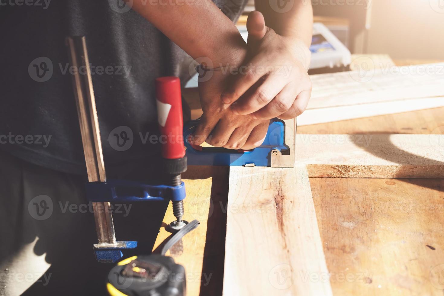 menuiserie d'entrepreneur tenant une agrafeuse pour assembler les pièces de bois comme le client l'a commandé. photo