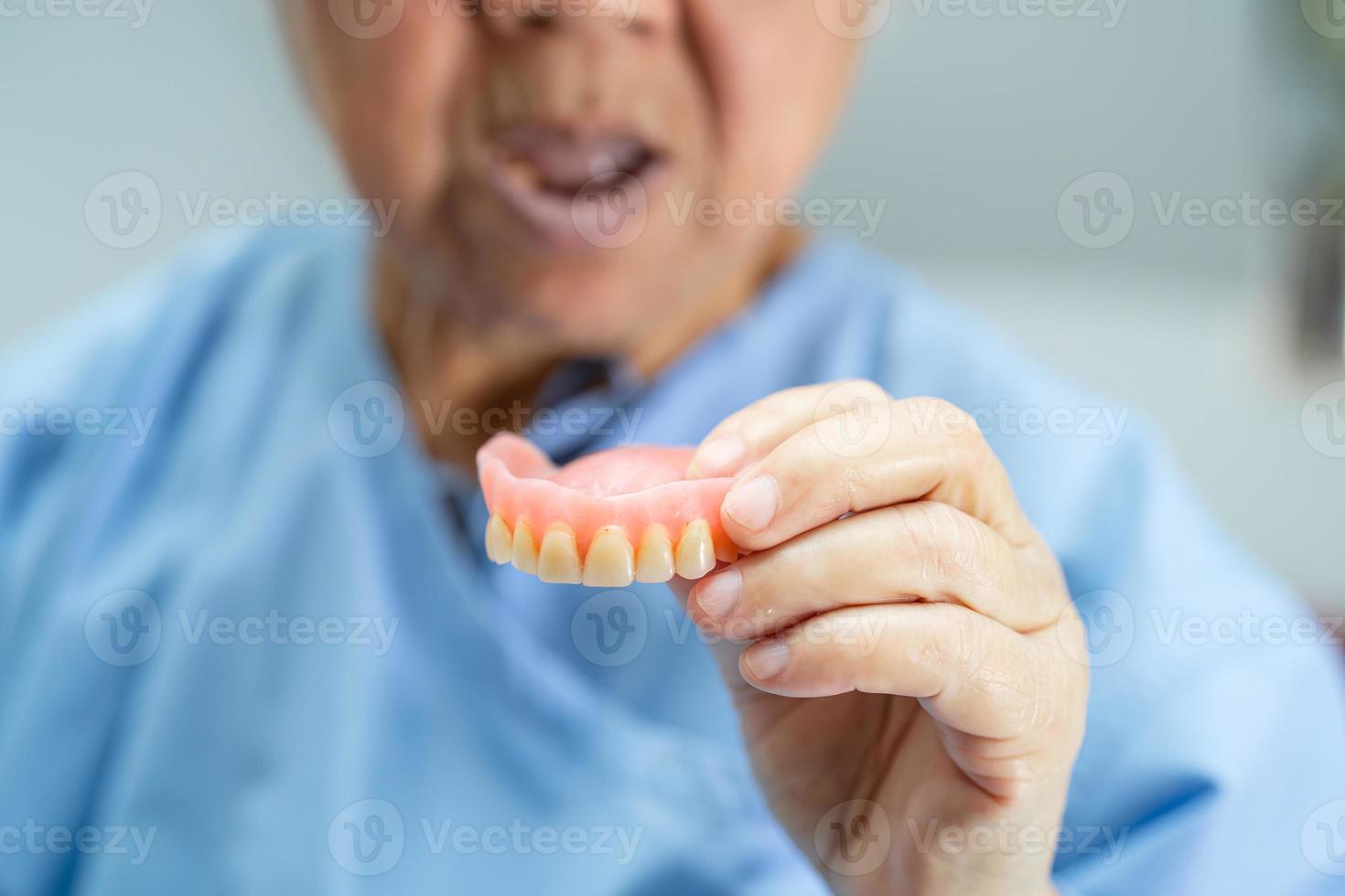 patiente asiatique âgée ou âgée tenant une prothèse dentaire dans un hôpital de soins infirmiers, concept médical solide et sain photo