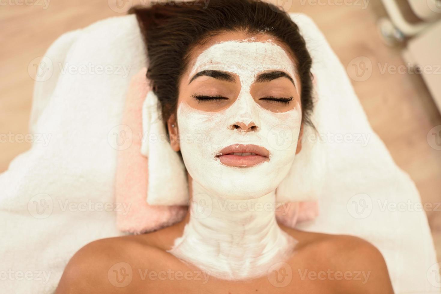 jeune femme avec un masque crème hydratant sur son visage photo