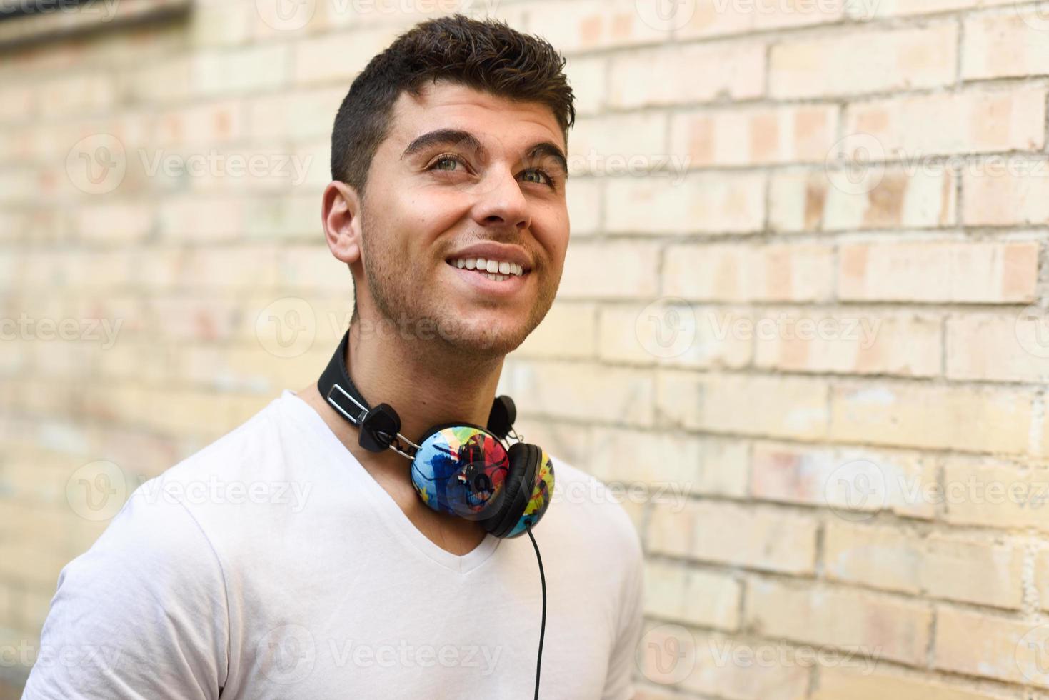 jeune homme en milieu urbain écoutant de la musique avec des écouteurs photo