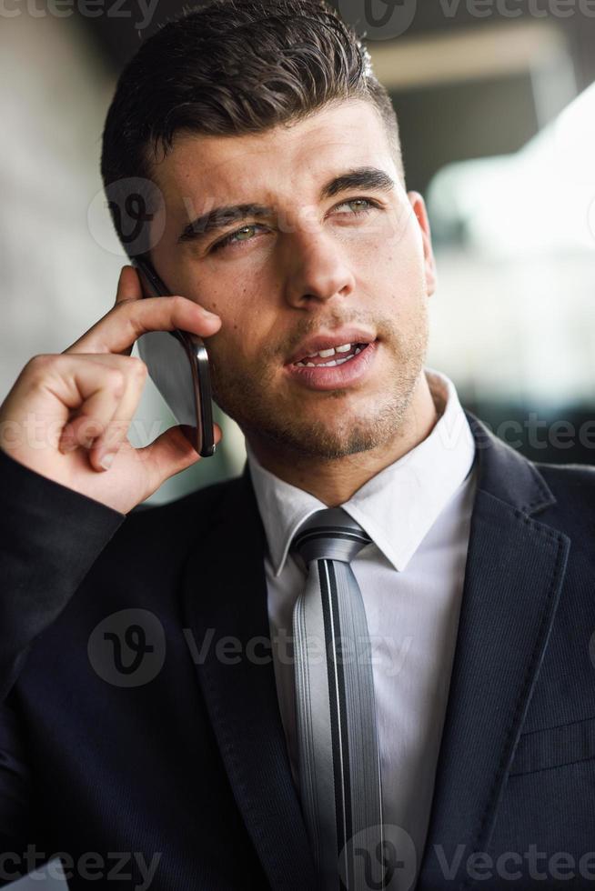 jeune homme d'affaires au téléphone dans un immeuble de bureaux photo