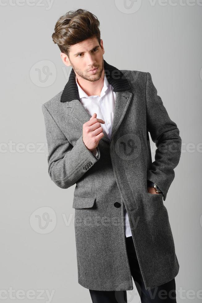 beau jeune homme portant un manteau. prise de vue en studio photo