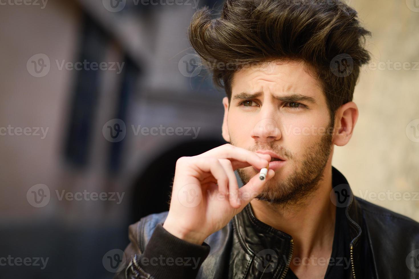 jeune homme fumant une cigarette photo