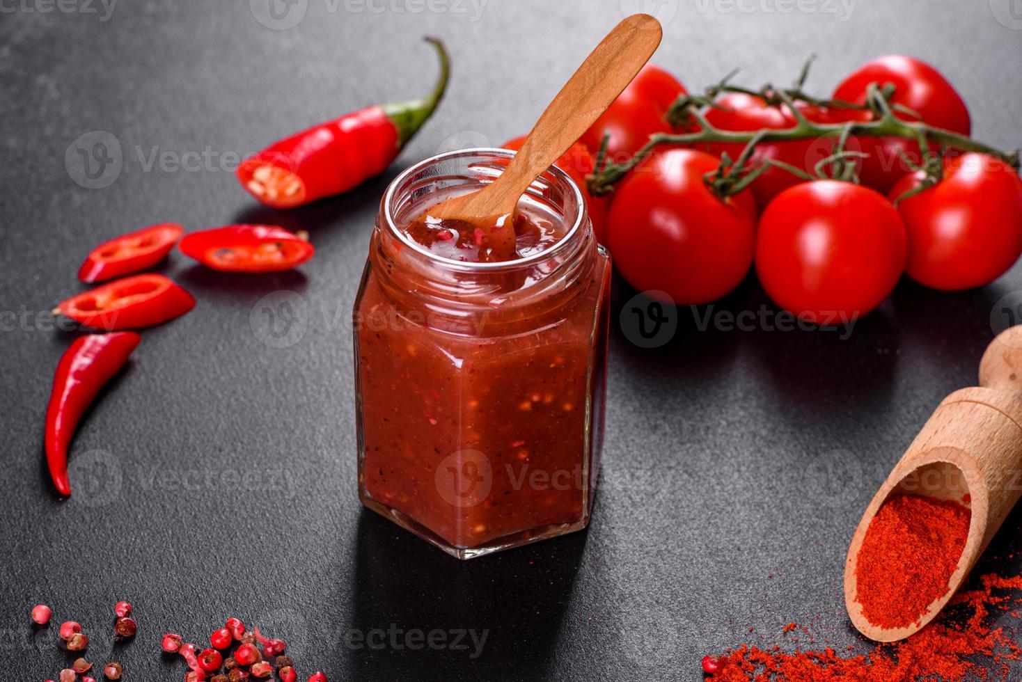 assaisonnement épicé de la cuisine géorgienne adjika dans un bol avec poivron rouge et ail photo