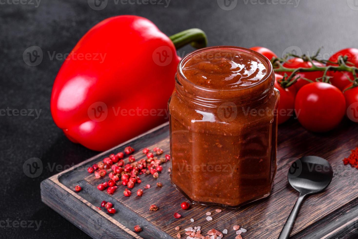 assaisonnement épicé de la cuisine géorgienne adjika dans un bol avec poivron rouge et ail photo