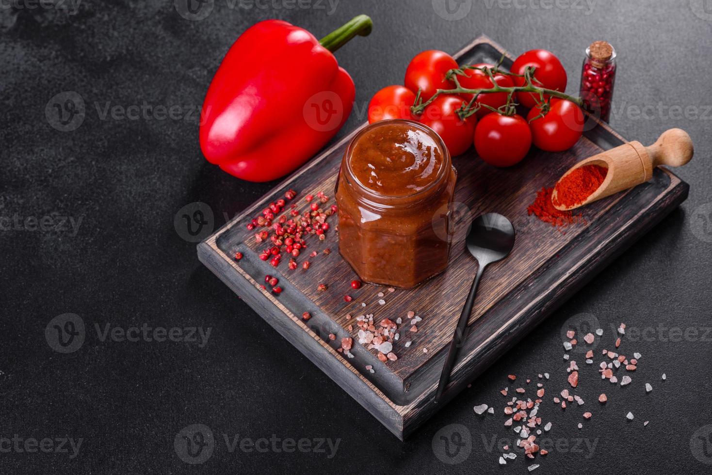 assaisonnement épicé de la cuisine géorgienne adjika dans un bol avec poivron rouge et ail photo