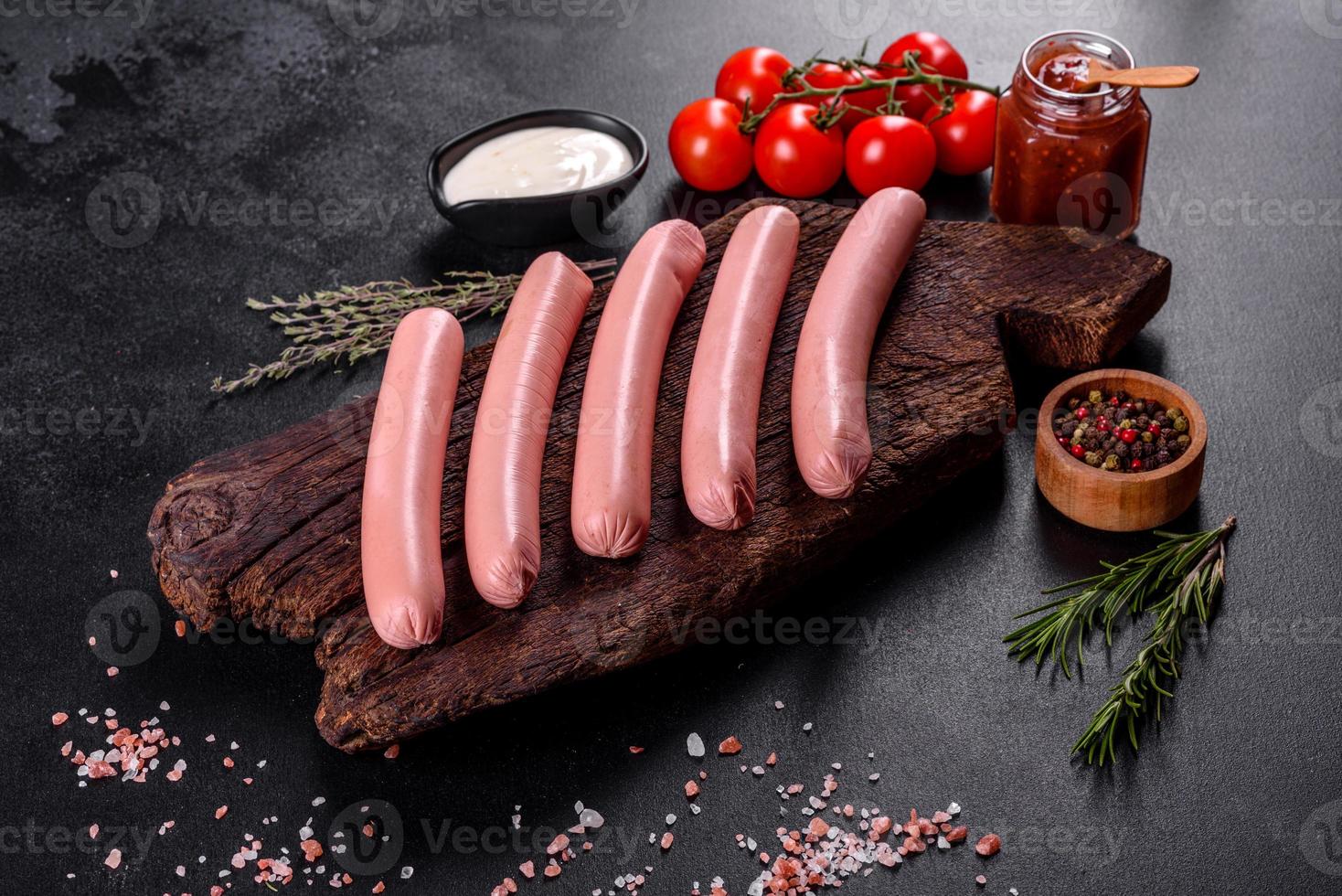 délicieuses saucisses bouillies fraîches avec des légumes et des épices photo