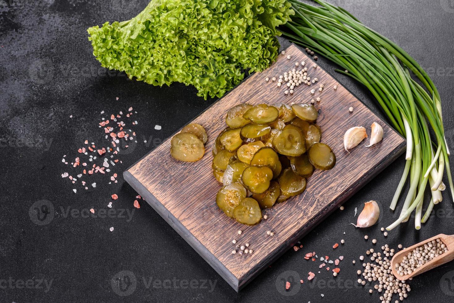 Savoureux concombre mariné épicé salé coupé avec des anneaux sur une planche à découper en bois photo