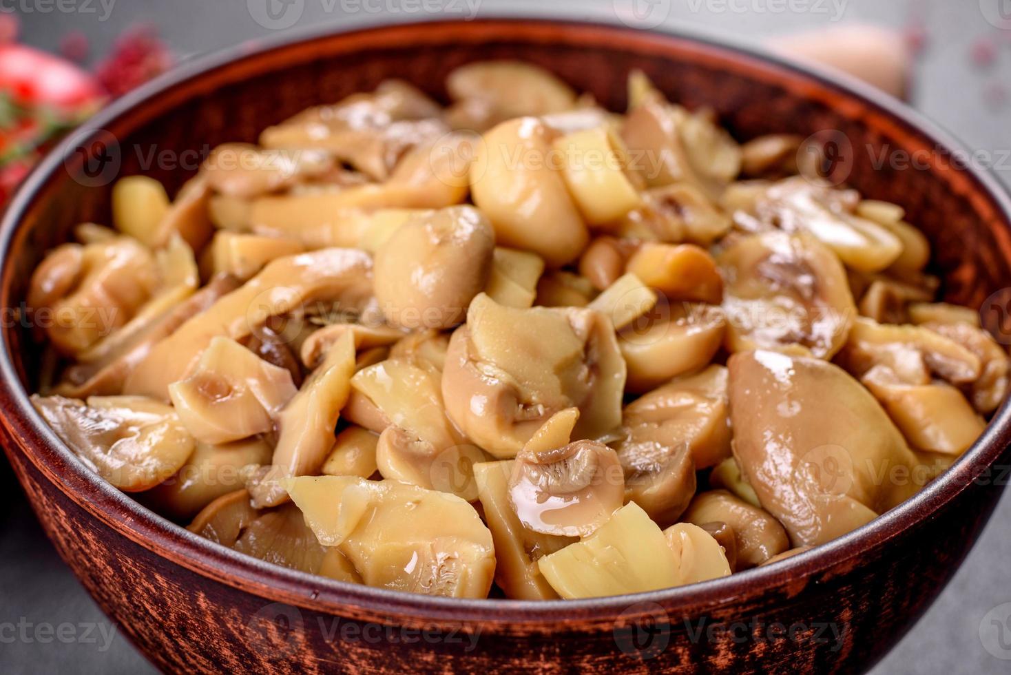 délicieux champignons en conserve épicés frais avec des épices et des herbes dans des plats en céramique photo