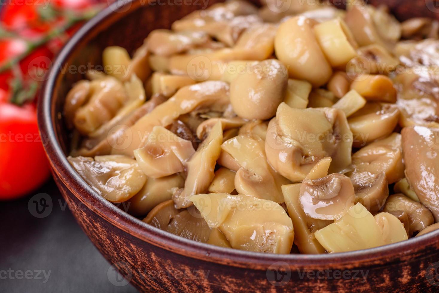 délicieux champignons en conserve épicés frais avec des épices et des herbes dans des plats en céramique photo