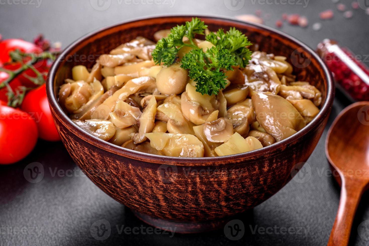 délicieux champignons en conserve épicés frais avec des épices et des herbes dans des plats en céramique photo