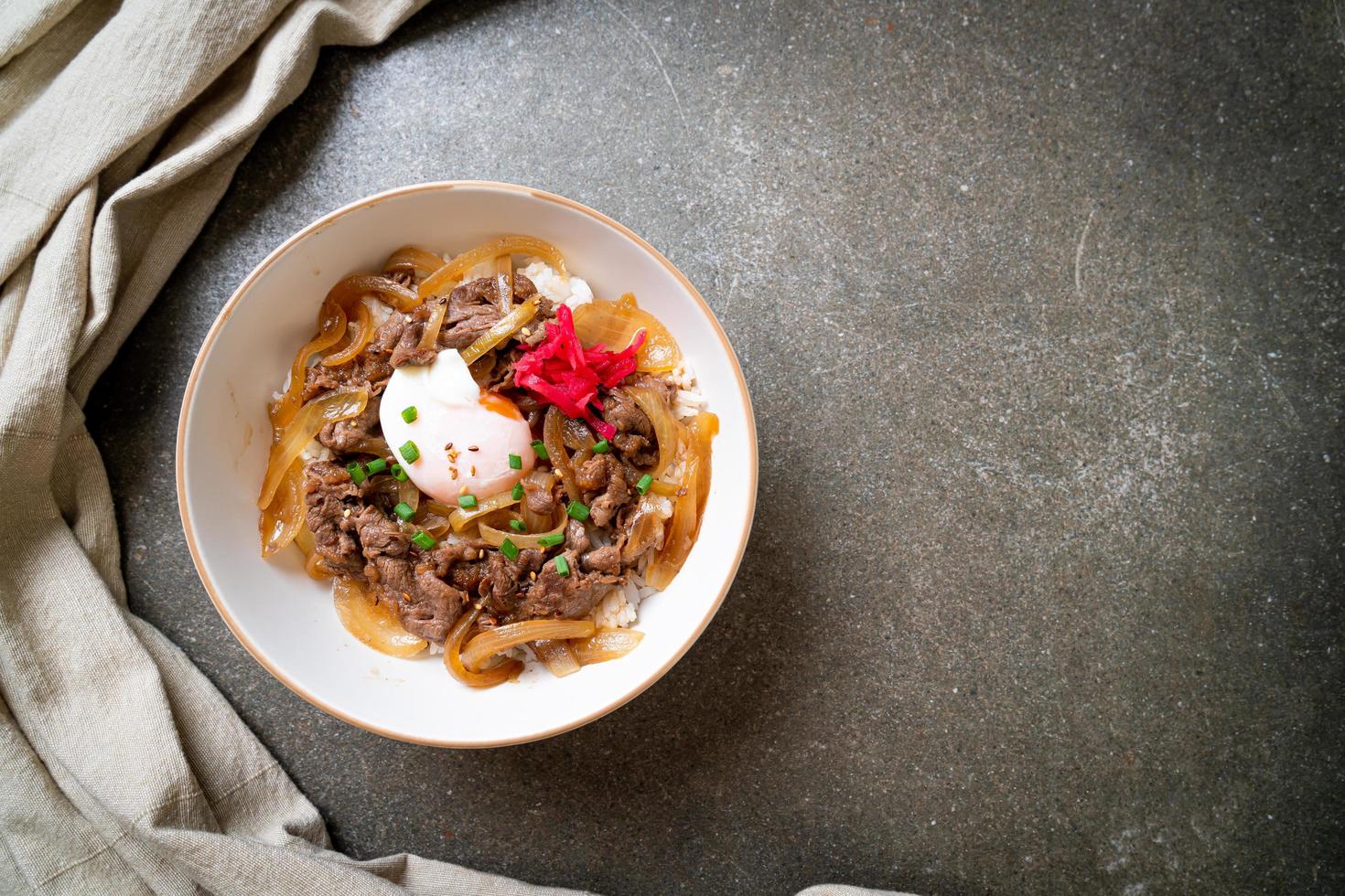 boeuf tranché sur riz garni avec oeuf, ou gyudon - style de cuisine japonaise photo