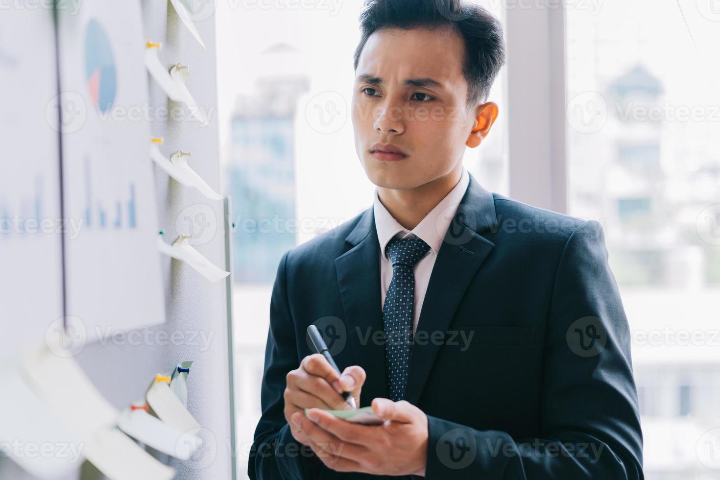 homme d'affaires asiatique planifiant une entreprise à côté du tableau du plan photo