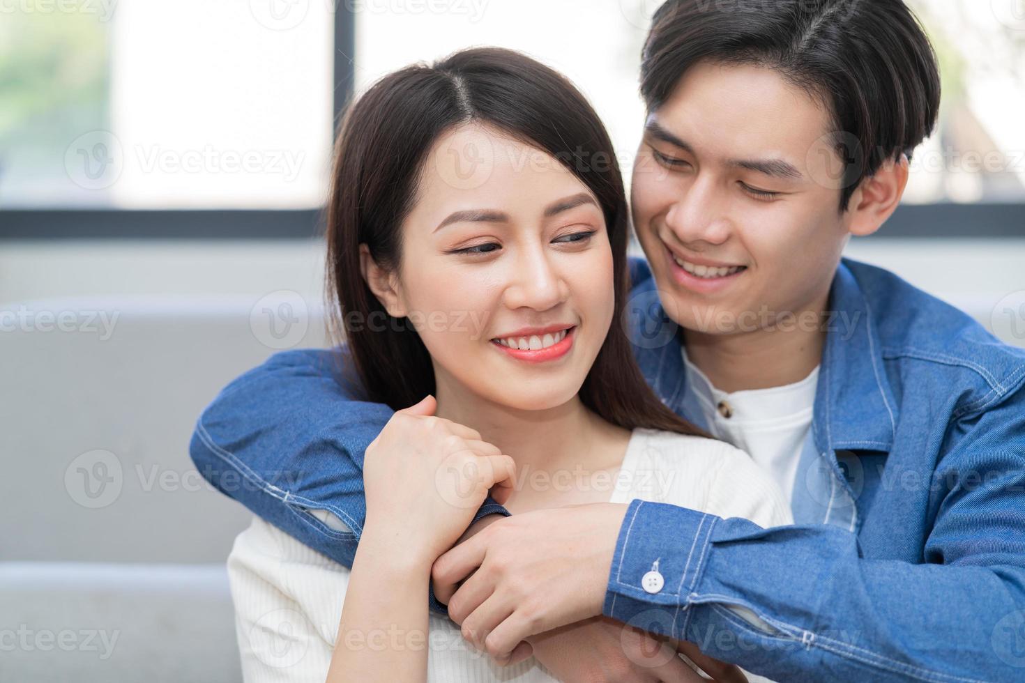 jeune couple asiatique s'embrassant joyeusement à la maison photo