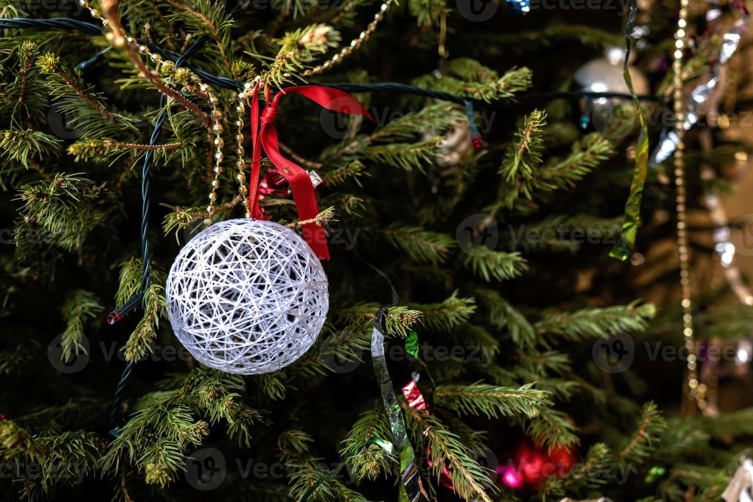 diverses décorations de Noël colorées pendent des branches d'épinette. photo