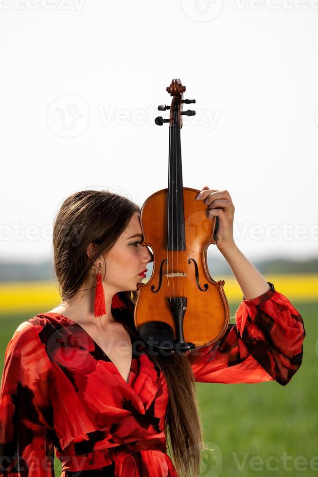 portrait d'une jeune femme positive. une partie du visage est recouverte par le manche du violon - image photo