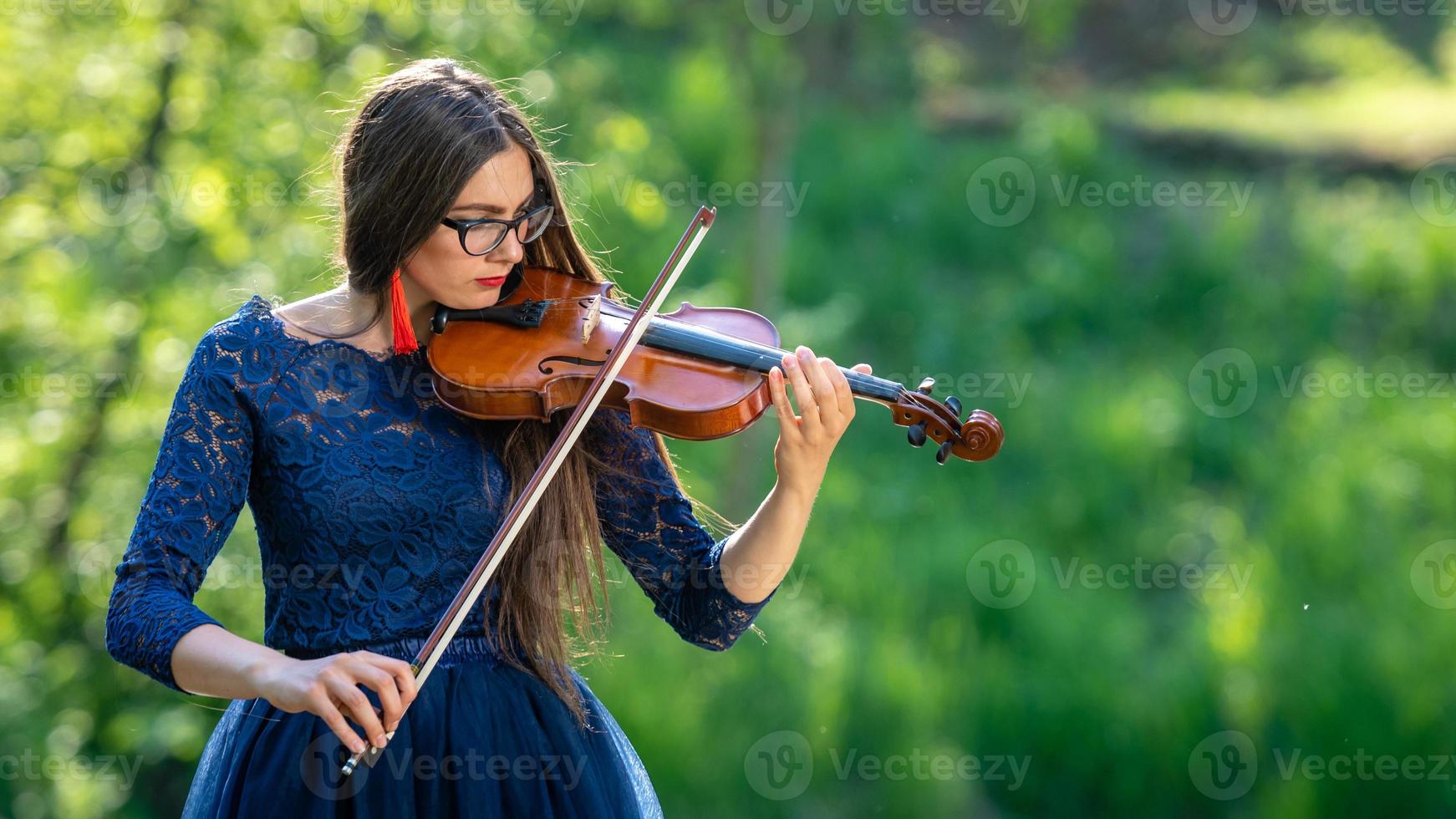 jeune femme jouant du violon au parc. faible profondeur de champ - image photo