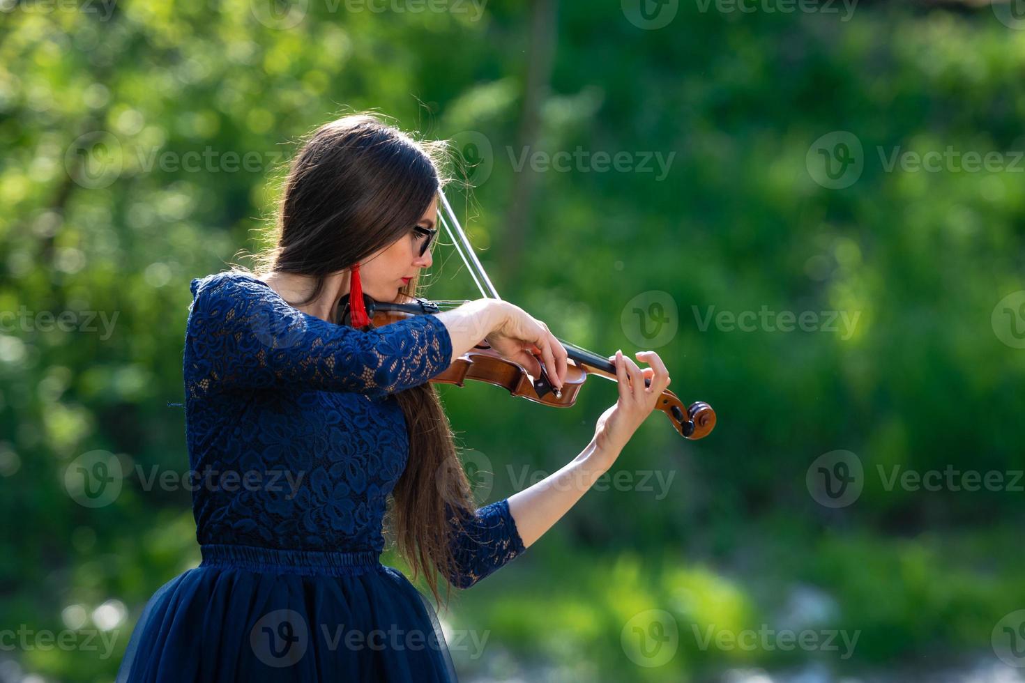 jeune femme jouant du violon au parc. faible profondeur de champ - image photo