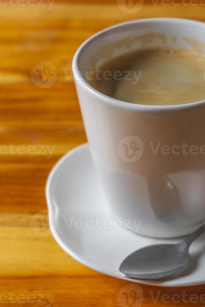 crème de café noir dans une tasse blanche sur une table en bois au laos. photo