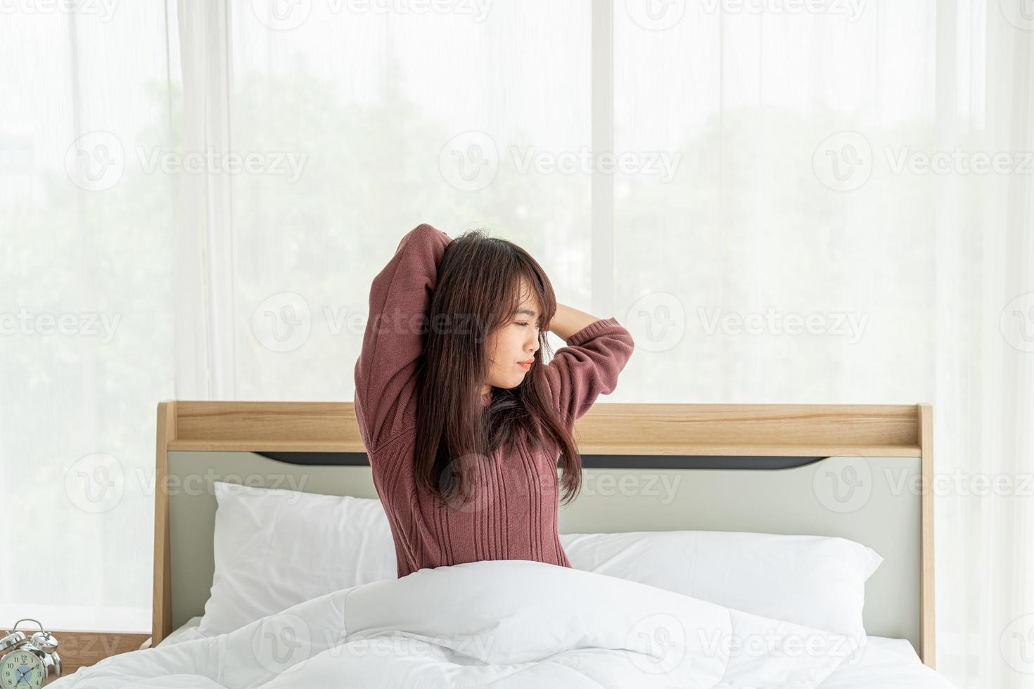 femme asiatique sur le lit et se réveillant le matin photo