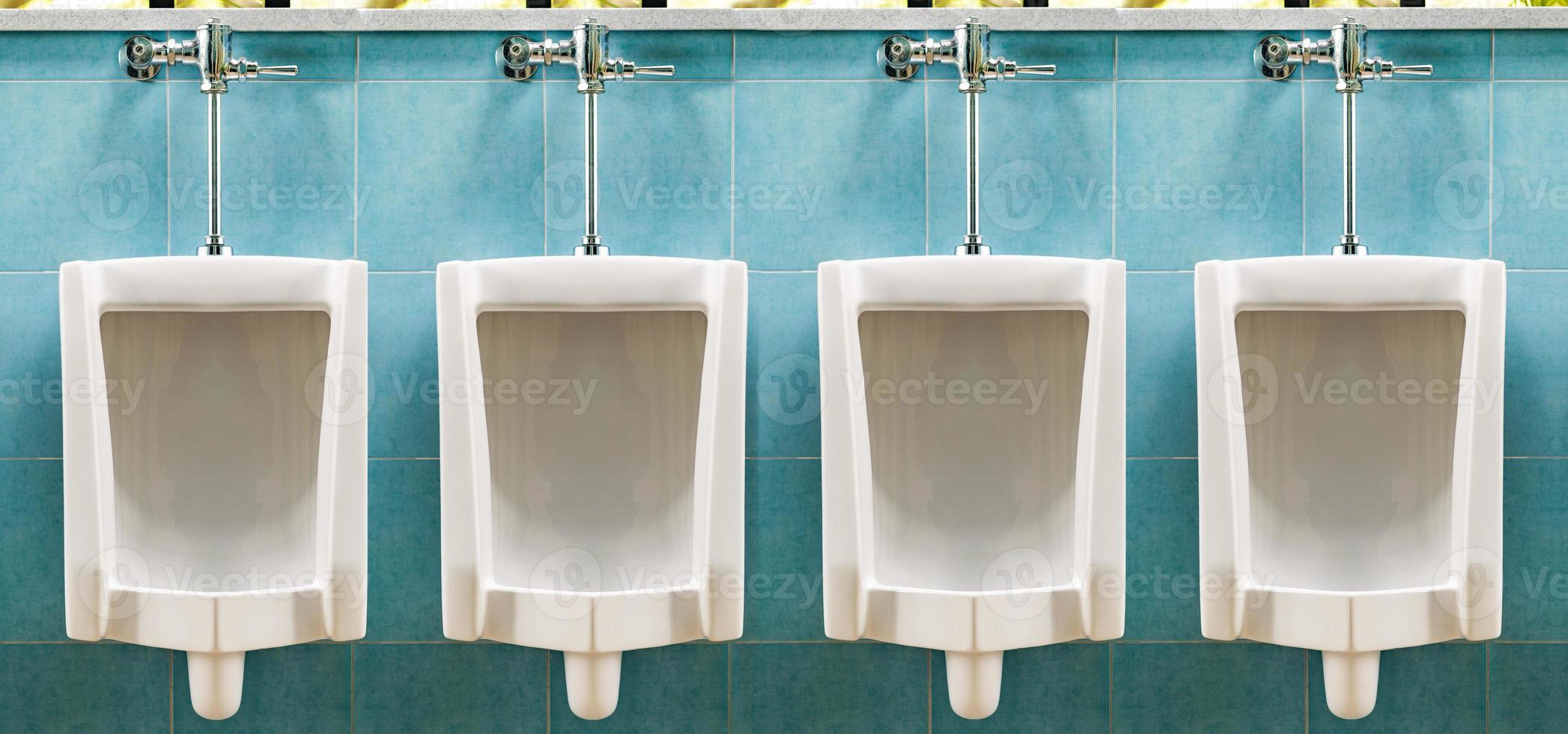 rangée d'urinoirs blancs dans les toilettes pour hommes photo