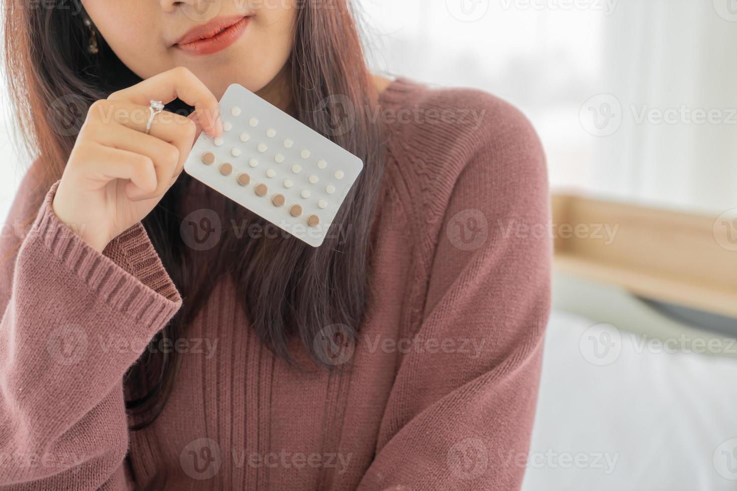 femme asiatique tenant la pilule contraceptive photo