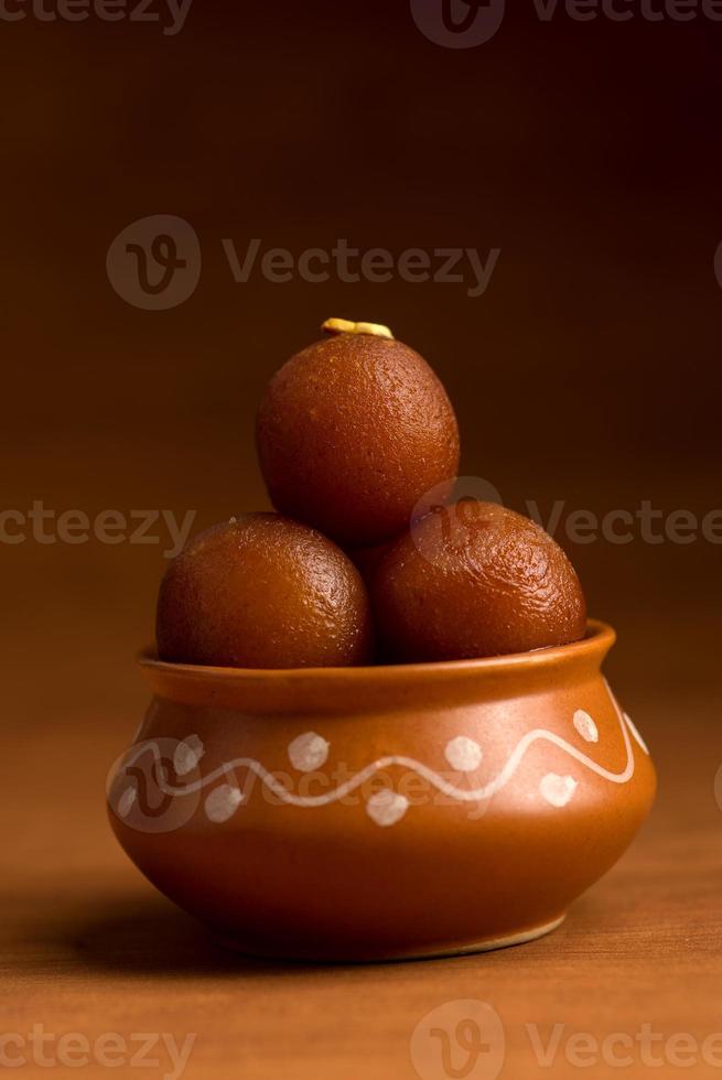 gulab jamun dans un pot en argile. dessert indien ou plat sucré photo
