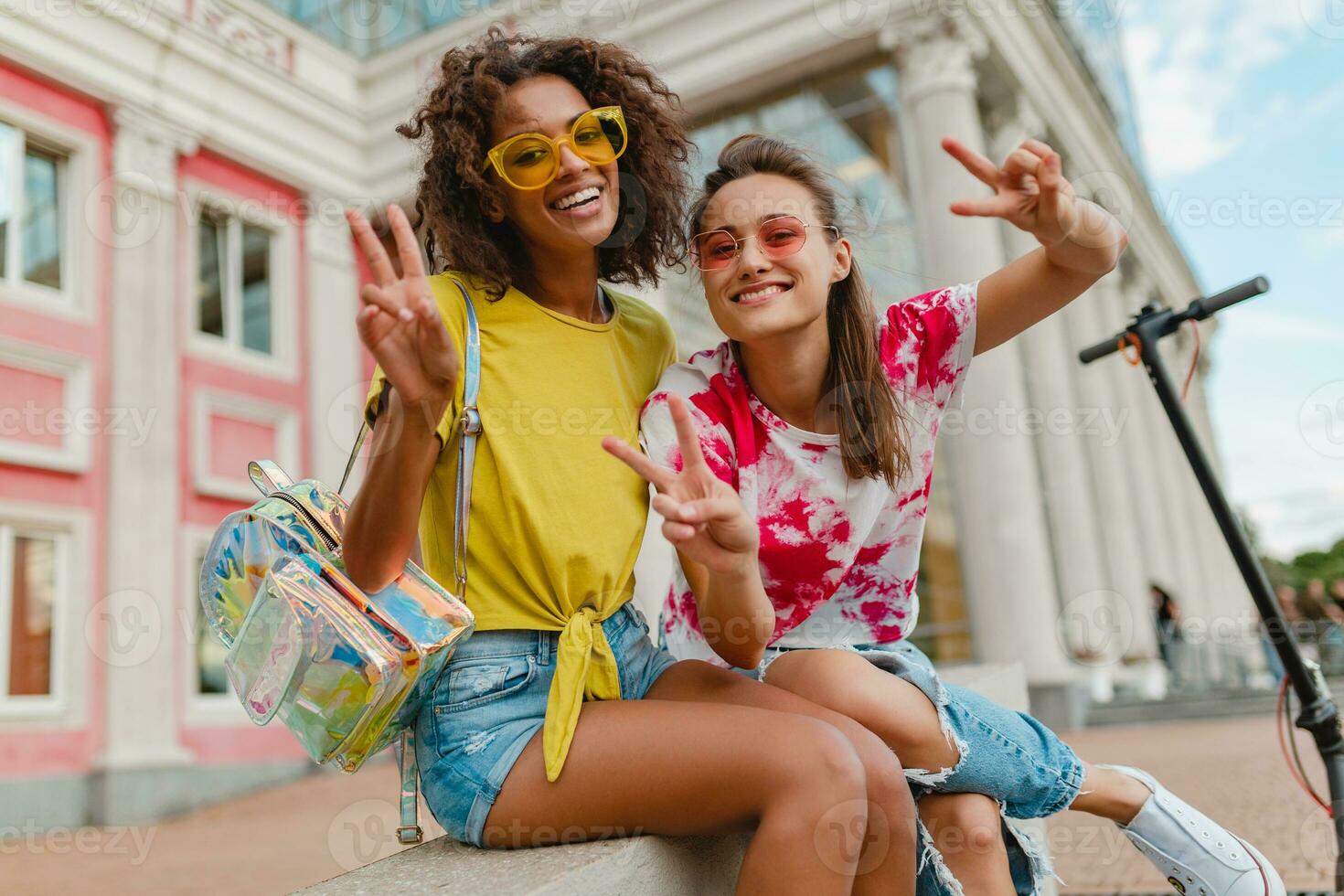 content Jeune les filles copains souriant séance dans rue photo