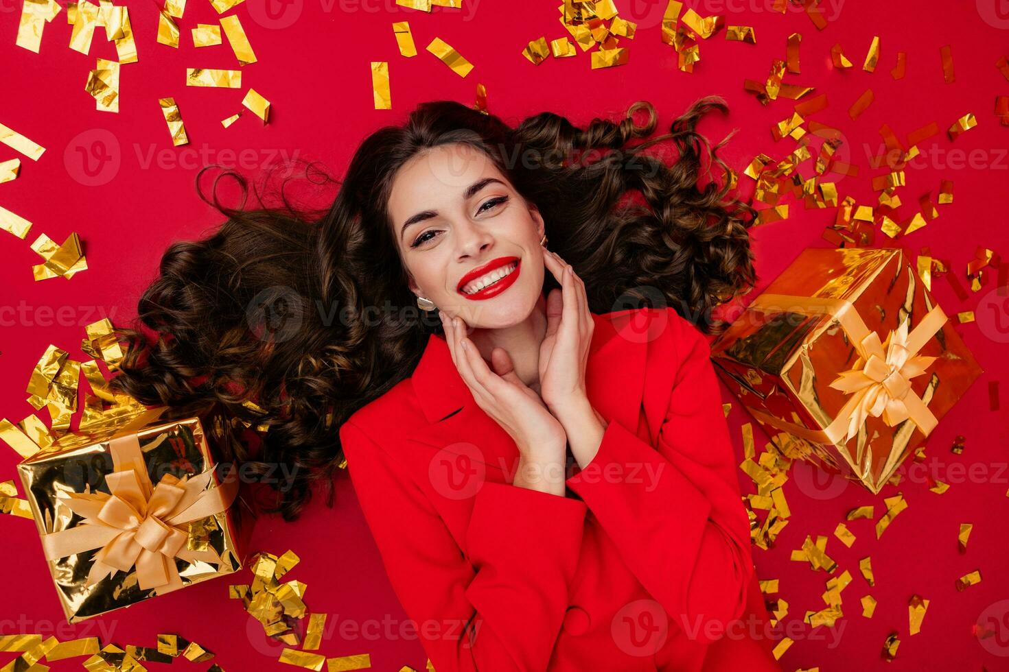 attrayant femme célébrer Noël sur rouge Contexte dans confettis photo