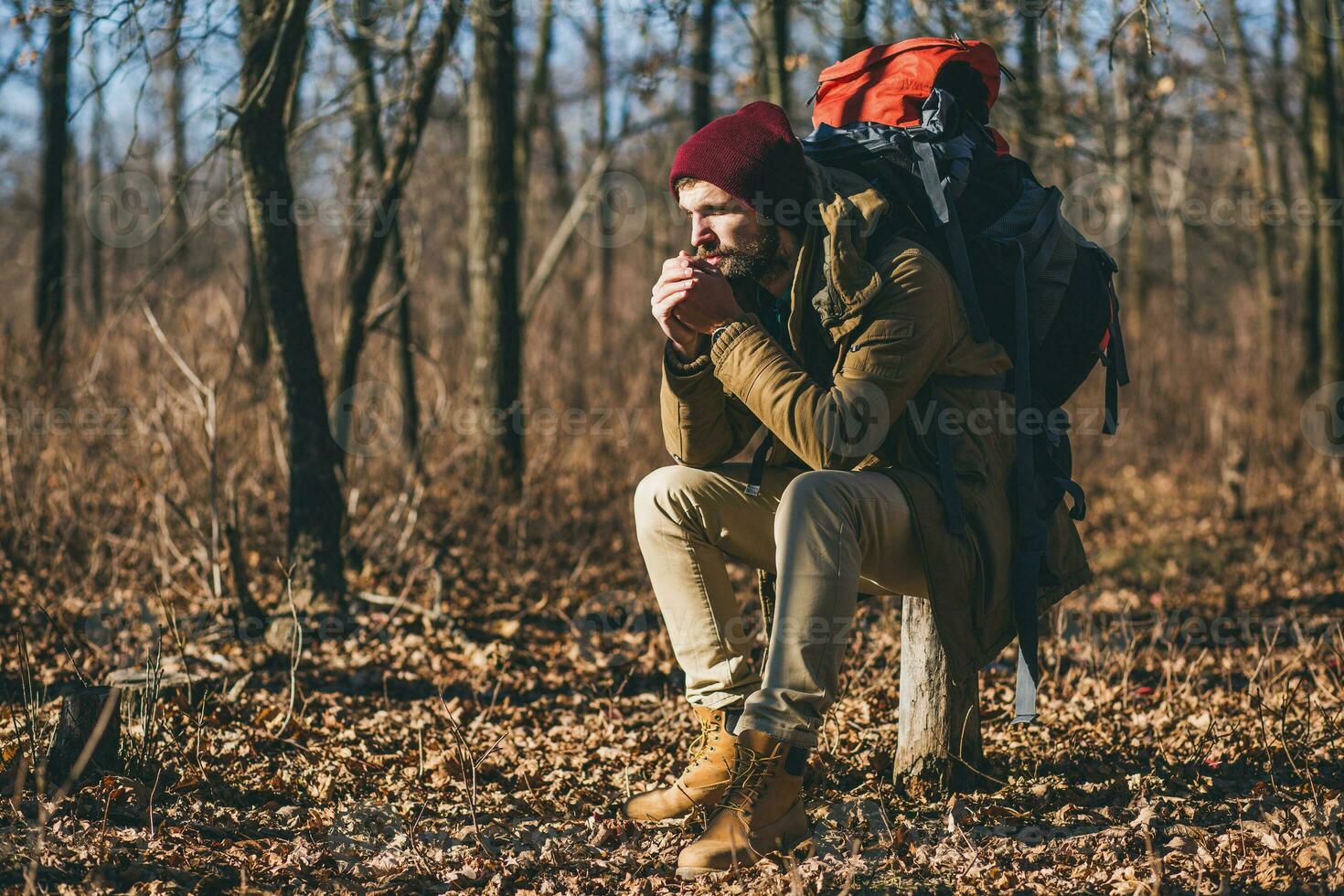 Jeune branché homme en voyageant avec sac à dos dans printemps l'automne forêt photo