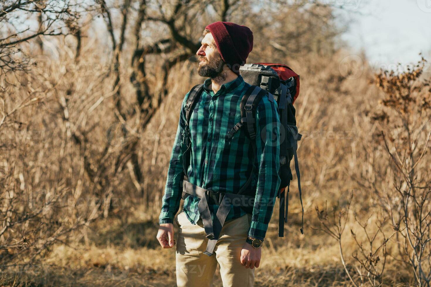 Jeune branché homme en voyageant avec sac à dos dans printemps l'automne forêt photo