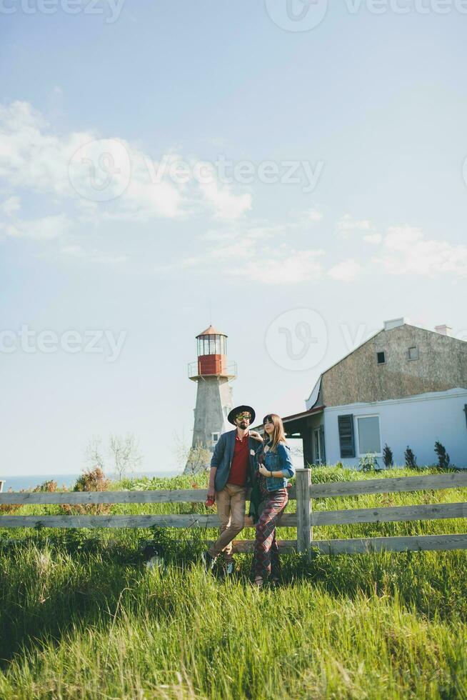 en riant Jeune branché couple indie style dans l'amour en marchant dans campagne photo