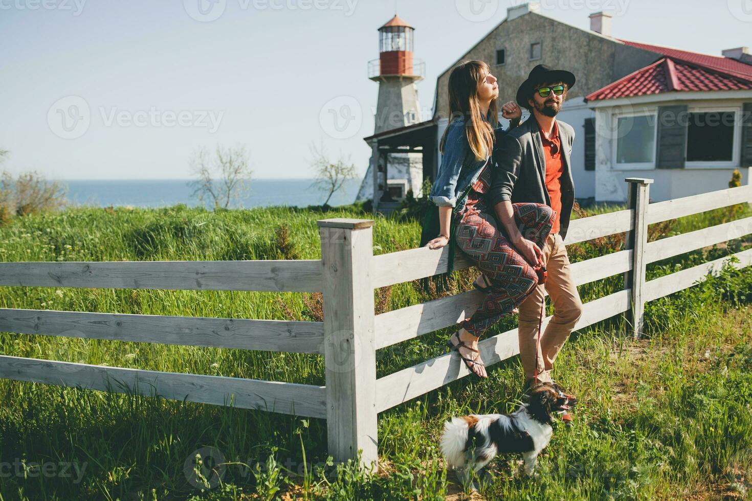 élégant branché couple dans l'amour en marchant avec chien dans campagne photo