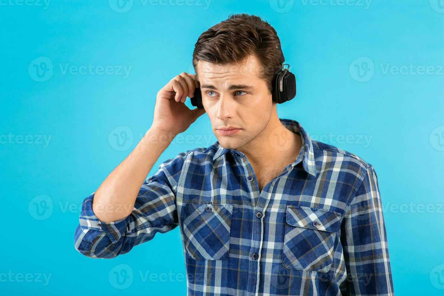 élégant Jeune homme écoute à la musique sur sans fil écouteurs photo