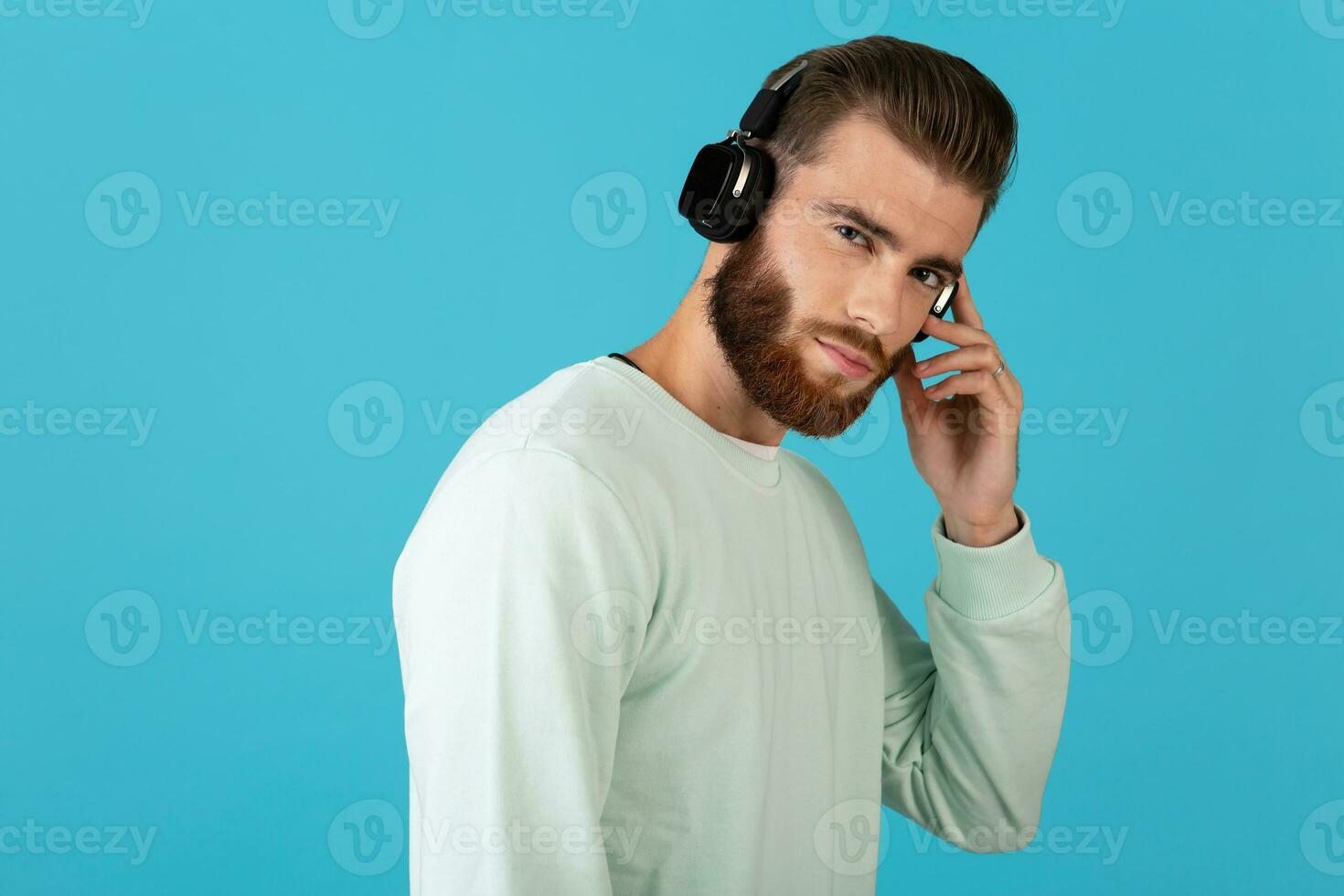 élégant Jeune homme écoute à la musique sur sans fil écouteurs photo