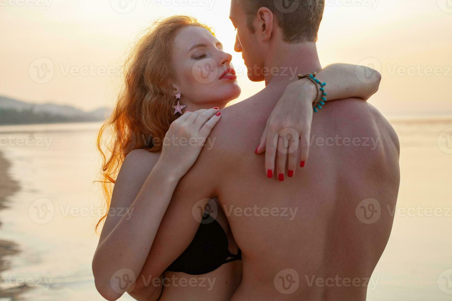 Jeune sexy romantique couple dans l'amour content sur été plage ensemble ayant amusement portant nager costume photo