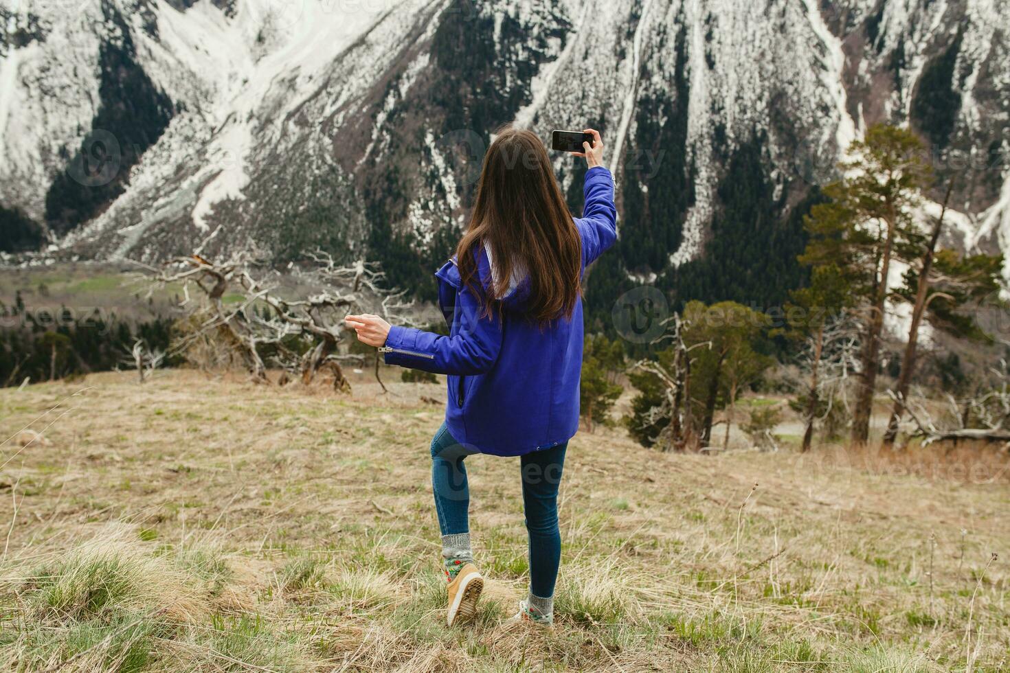 Jeune branché femme en marchant dans montagnes photo
