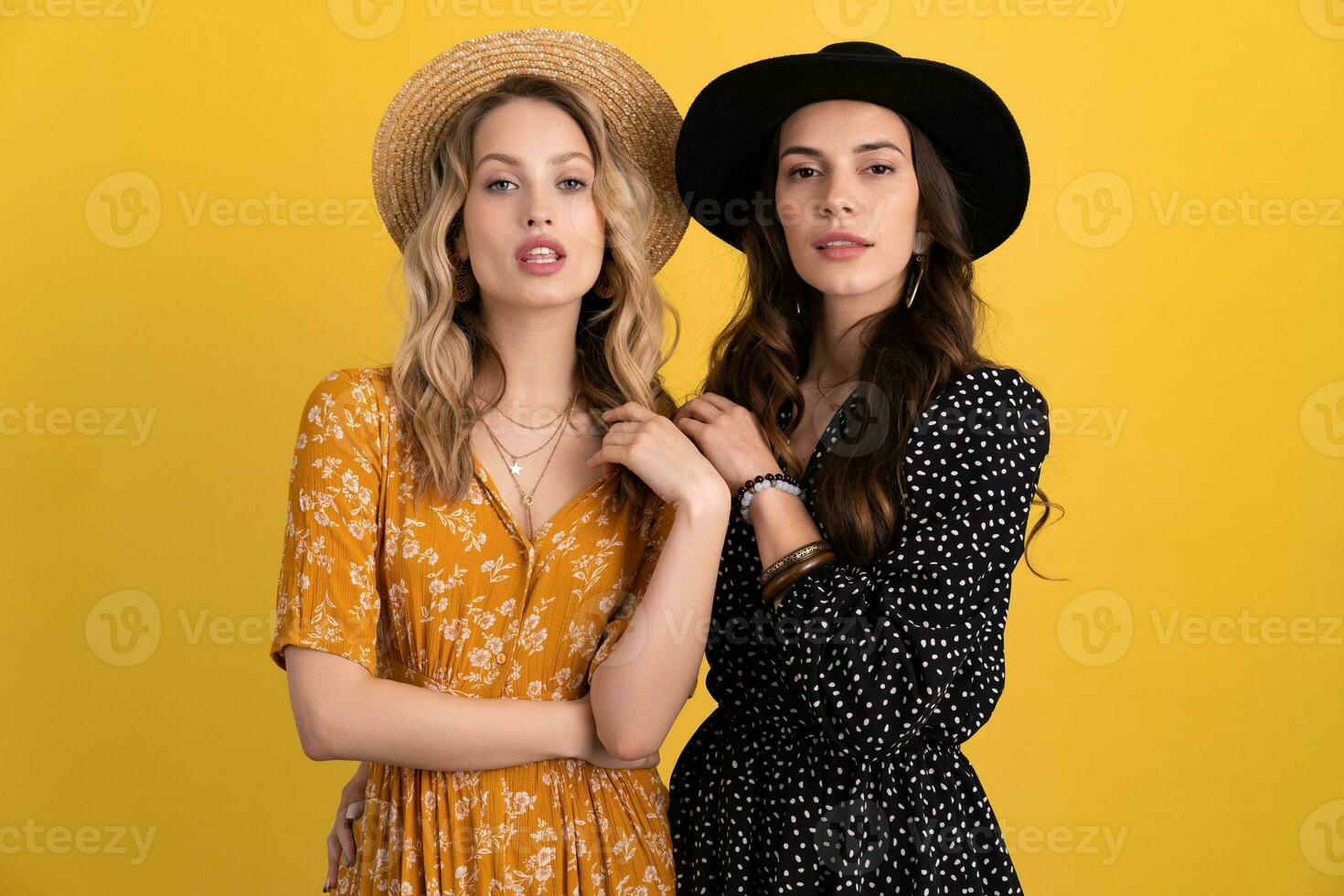 magnifique femmes copains ensemble isolé sur Jaune Contexte dans noir et Jaune robe et chapeau photo