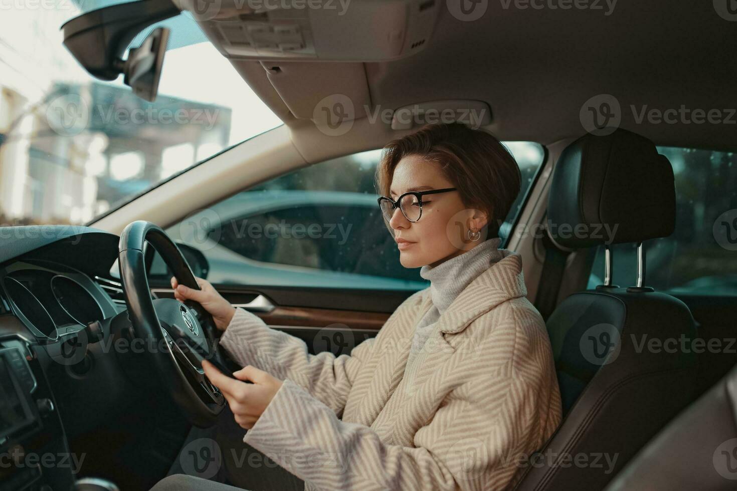 attrayant élégant femme séance dans voiture habillé dans manteau photo