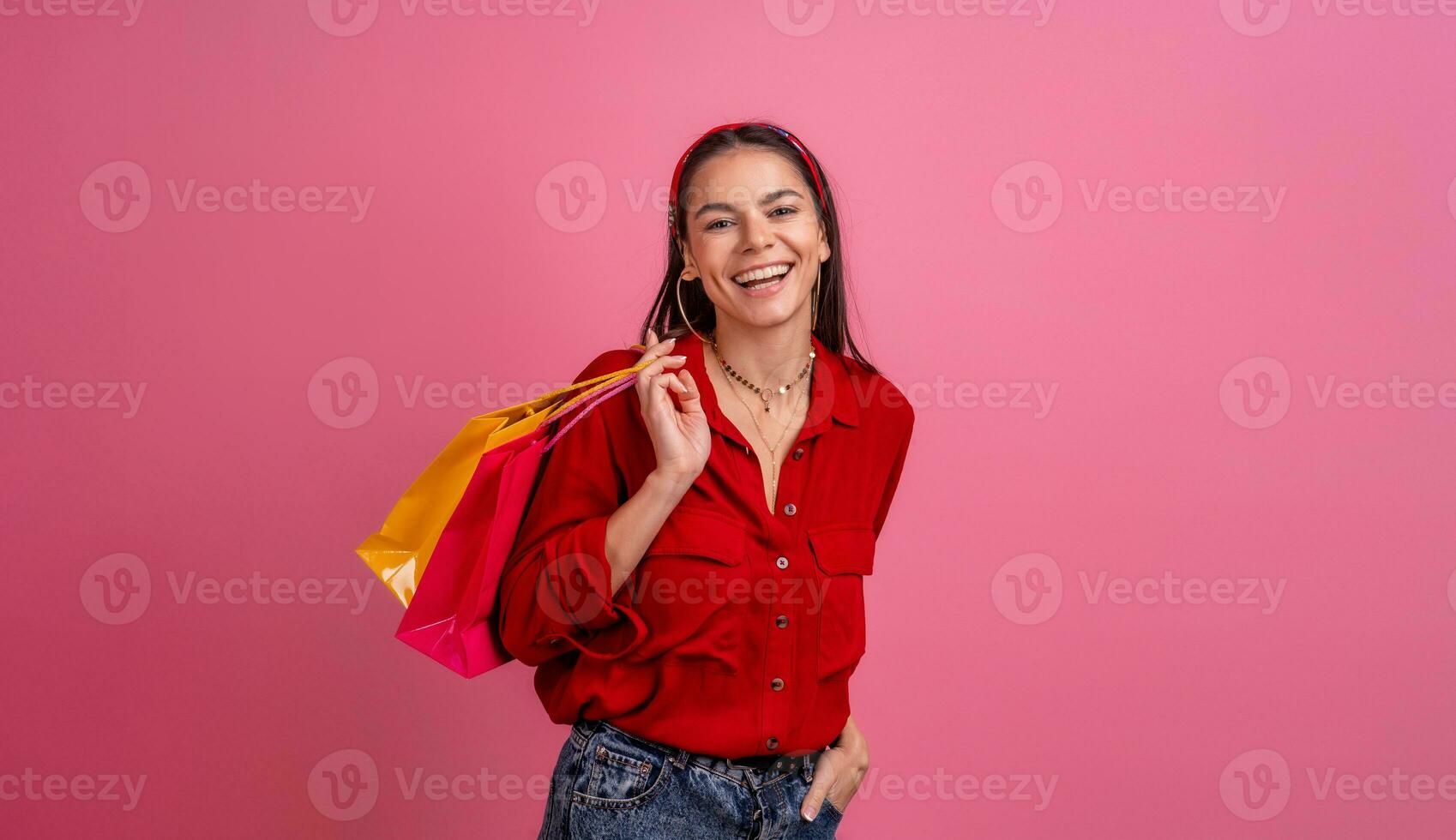 hispanique magnifique femme dans rouge chemise souriant en portant en portant achats Sacs photo