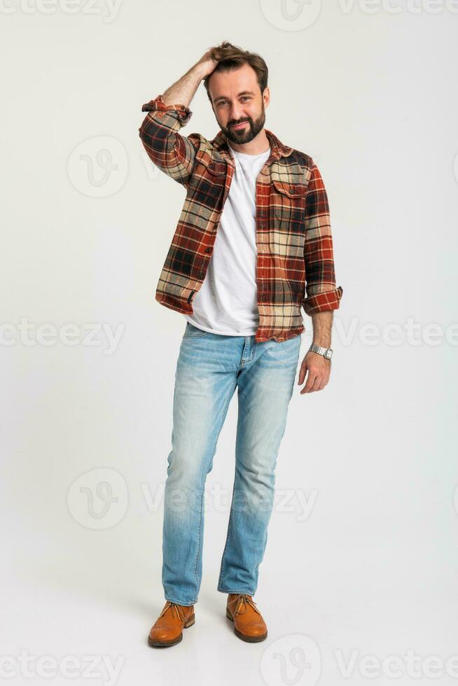 Beau barbu homme dans branché tenue habillé dans jeans et à carreaux chemise photo