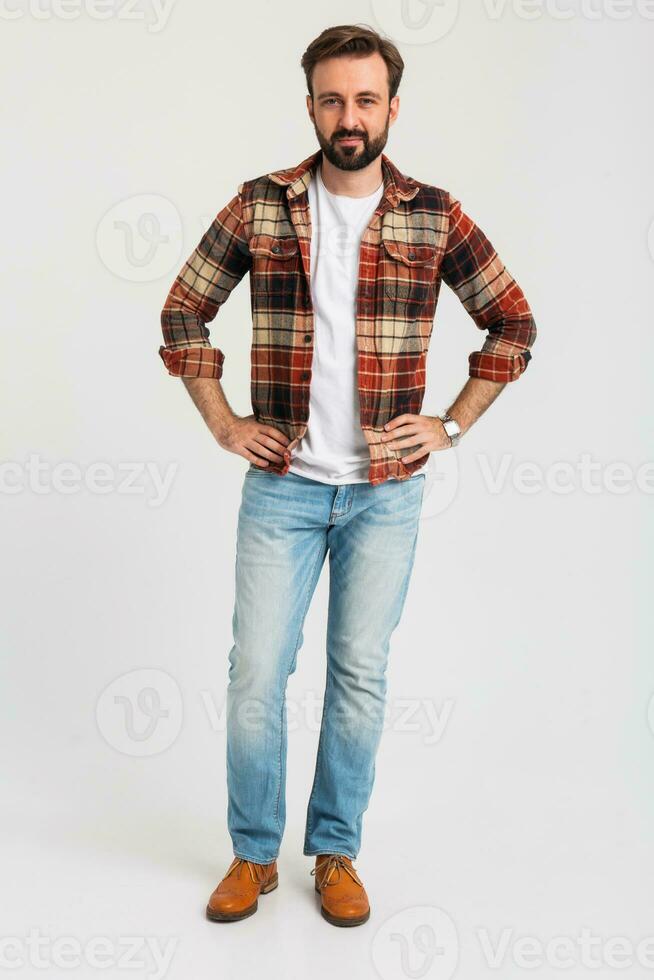 Beau barbu homme dans branché tenue habillé dans jeans et à carreaux chemise photo