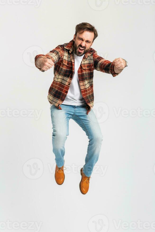 Beau barbu homme dans branché tenue habillé dans jeans et à carreaux chemise photo