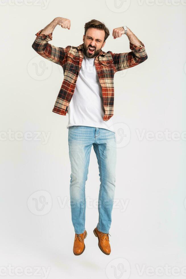 Beau barbu homme dans branché tenue habillé dans jeans et à carreaux chemise photo