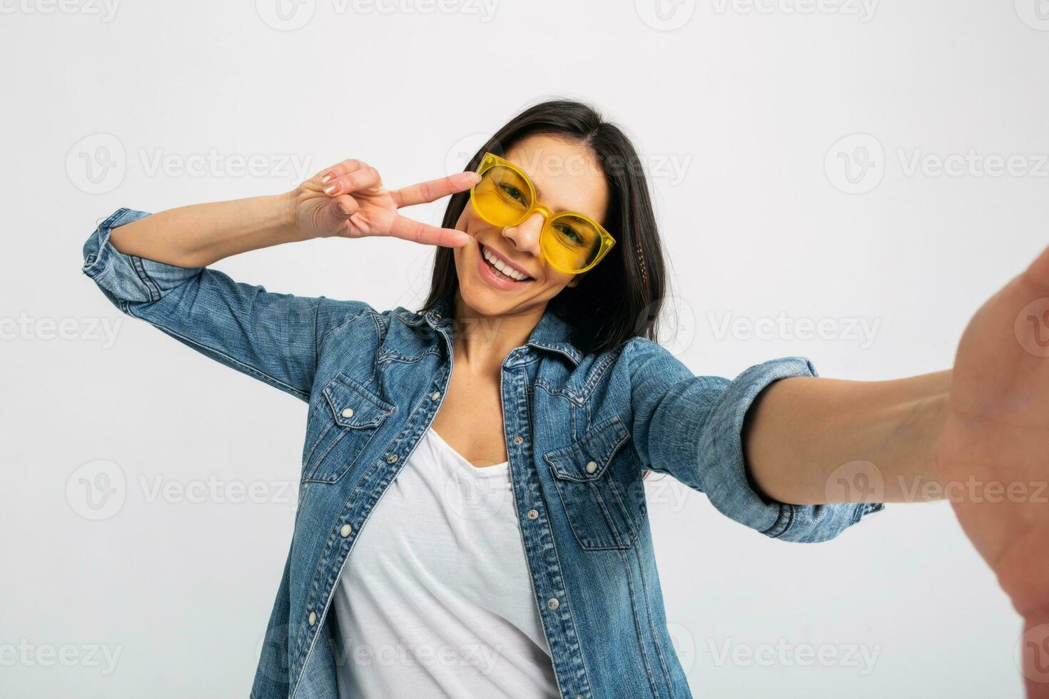 attrayant femme habillé jeans et denim chemise portant Jaune des lunettes de soleil photo