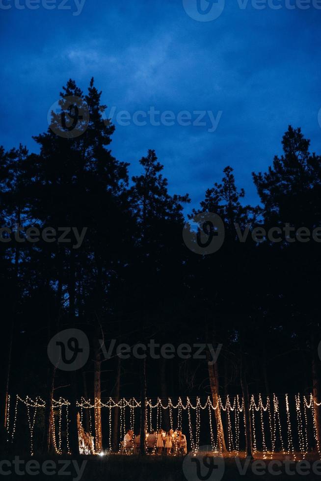 zone de banquet de mariage dans une forêt de pins avec une arche en arrière-plan pour plusieurs personnes photo