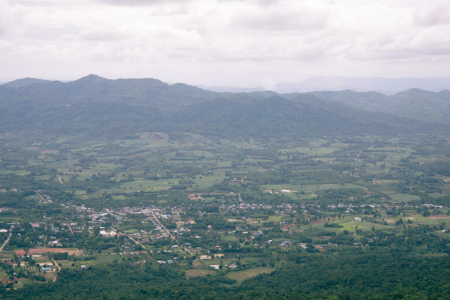 une village dans Thaïlande entouré par gros vert montagnes. photo